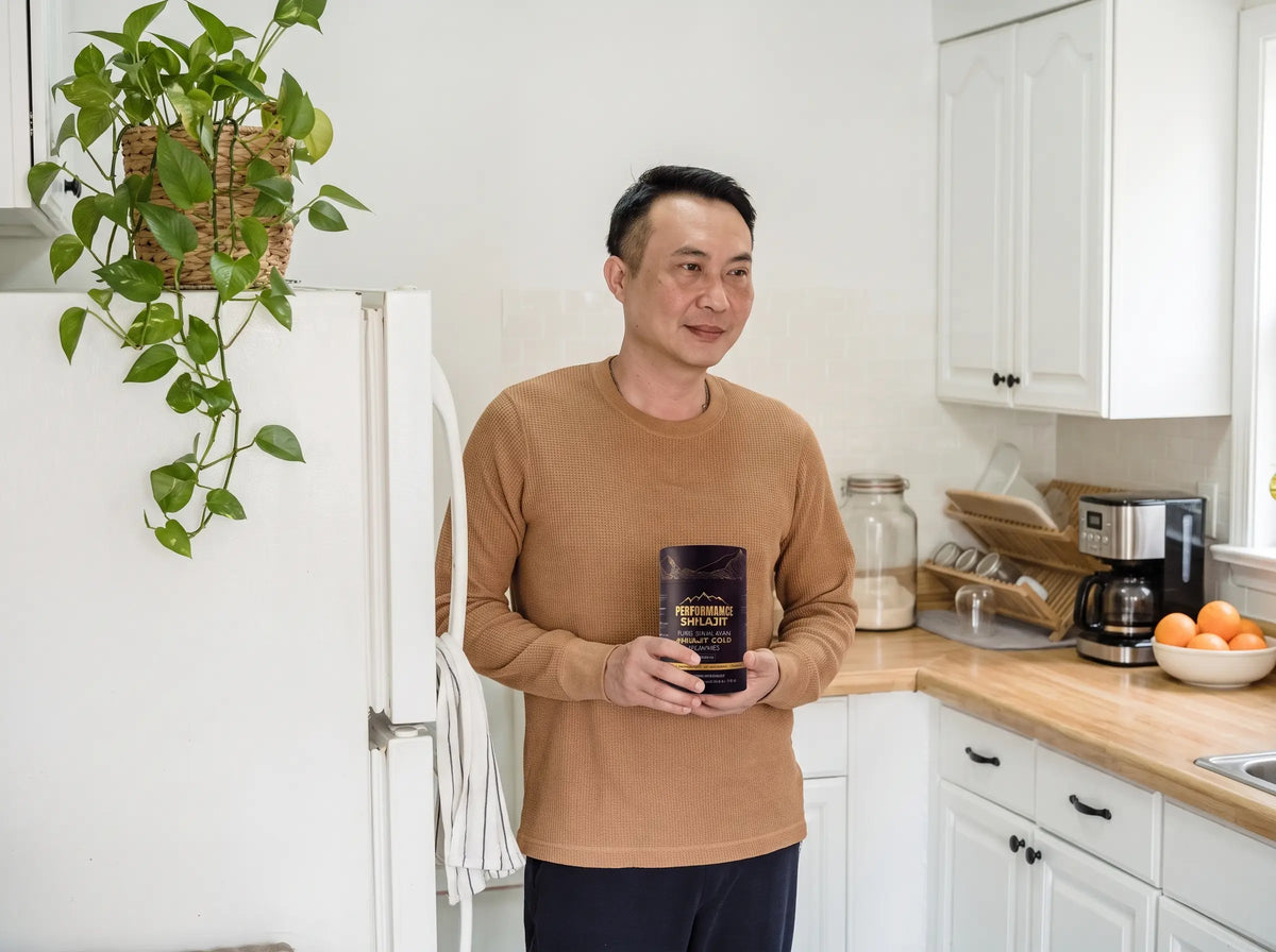 Man in his 40s holding a jar of Performance Shilajit in his kitchen